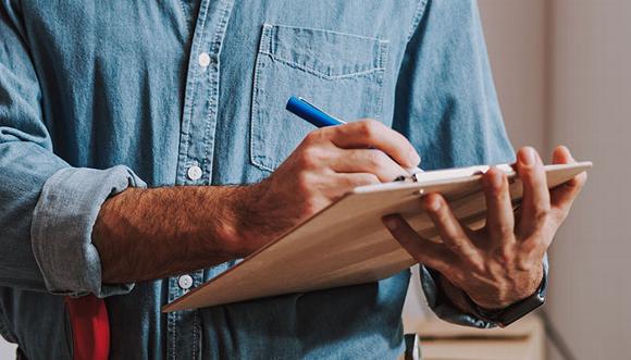 man checking off list on board in home 