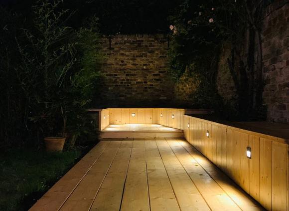 garden deck at night, lit up with feature lights