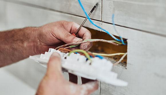 electrician looking over plug socket