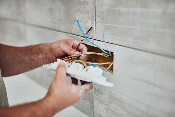 electrician installing socket in kitchen